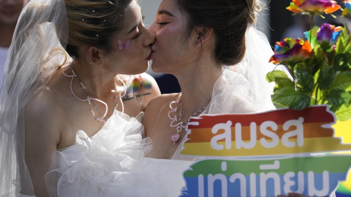 Women kiss while holding a poster to support marriage equality, during a Pride Parade in Bangkok, Thailand, June 4, 2023. ©2023 AP Photo/Sakchai Lalit, File