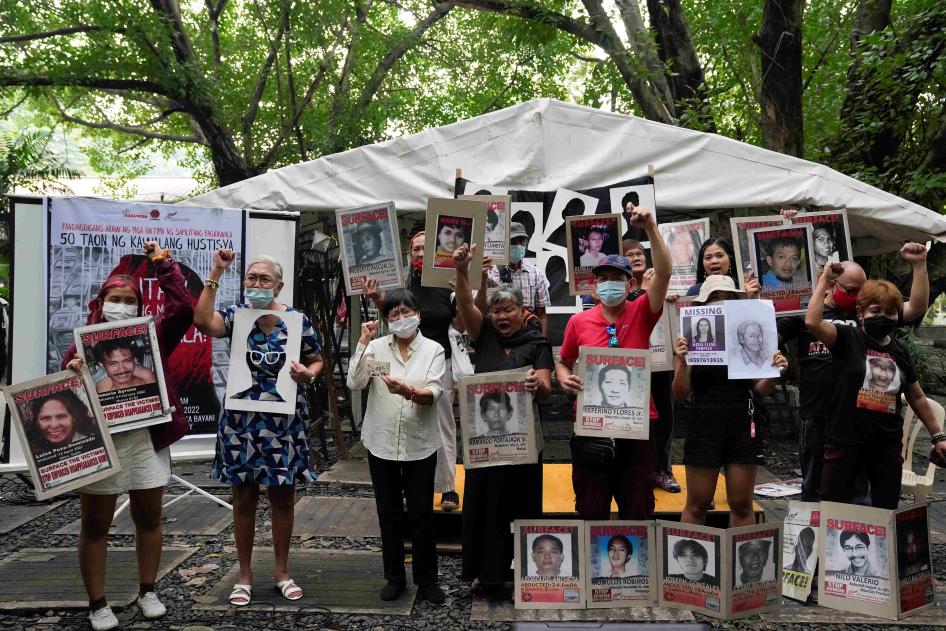 Para kerabat dan pendukung korban penghilangan paksa meneriakkan slogan sambil memegang foto orang terkasih mereka dalam sebuah pertemuan di Monumen Pahlawan di Manila, Filipina, 30 Agustus 2022. 